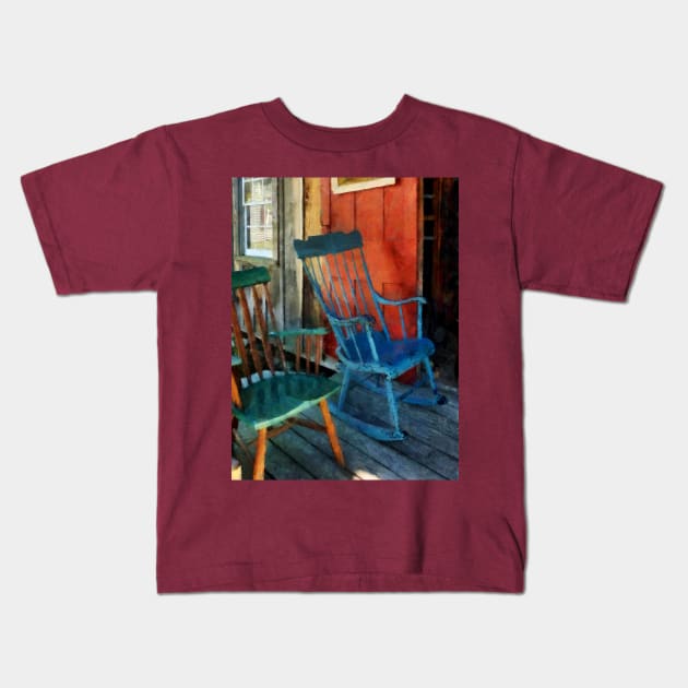 Blue and Green Rocking Chairs Against Red Door Kids T-Shirt by SusanSavad